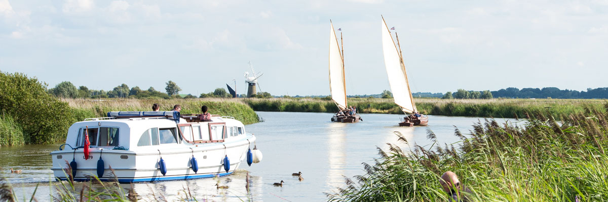 motor cruisers and sailing vessels on the river on a sunny day