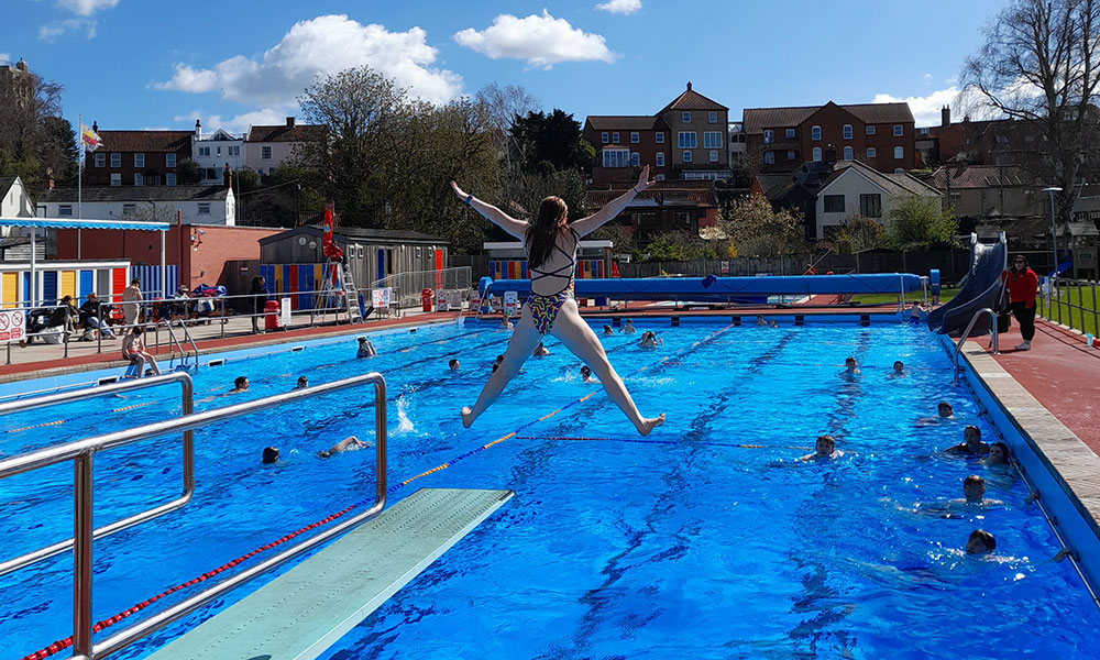 A youngster doing a star jump into the pool at Beccles Lido, on a sunny day