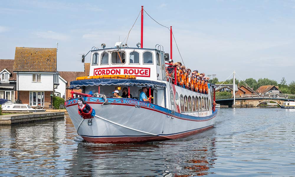 Visitors enjoying a guided river trip with Broads Tours on the Norfolk Broads on Cordon Rouge
