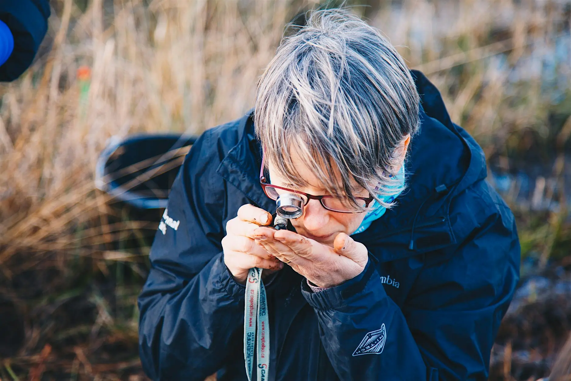 A Broads Authority Ranger looking through a magnifying glass