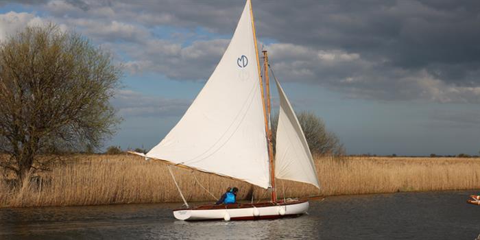 Sailing dinghy on calm Norfolk Broads water