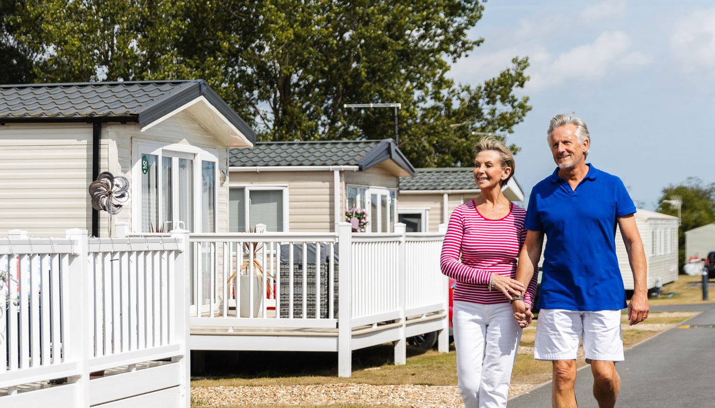 A middle aged couple stroll through lodges, hand in hand