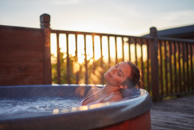 Person enjoying a hot tub at sunset