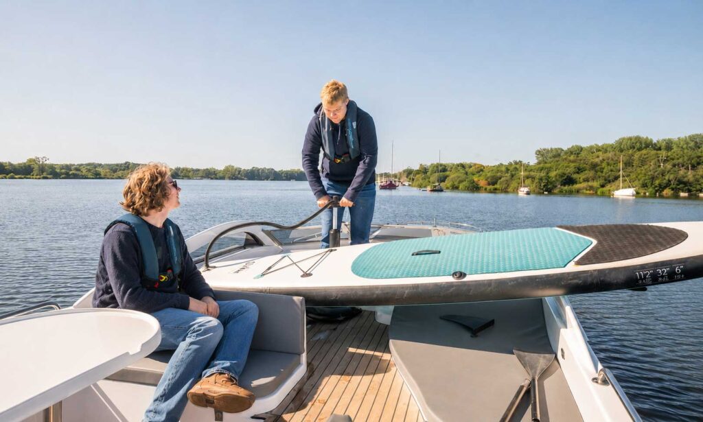 Blowing up a stand up paddleboard on the back of a holiday cruiser