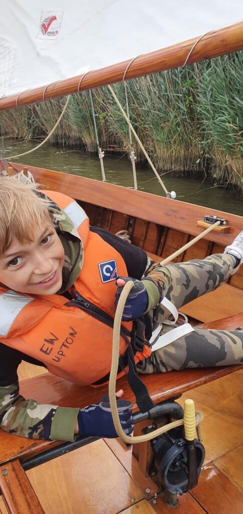 young boy enjoying sailing a yacht