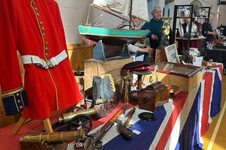 Stall at antique fair in Loddon, red military jacket and model yacht on display